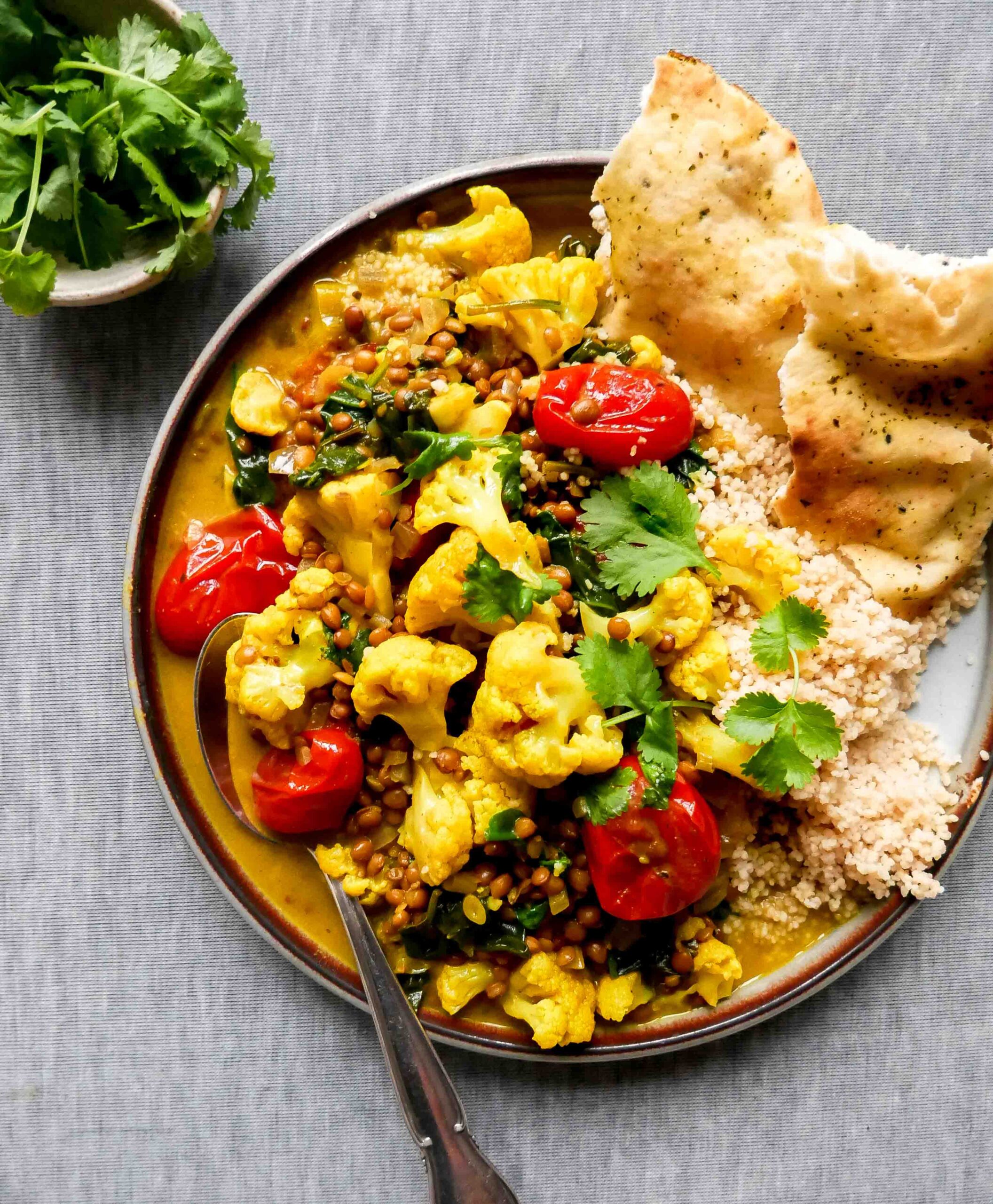 served curry with flatbreads and vegetables